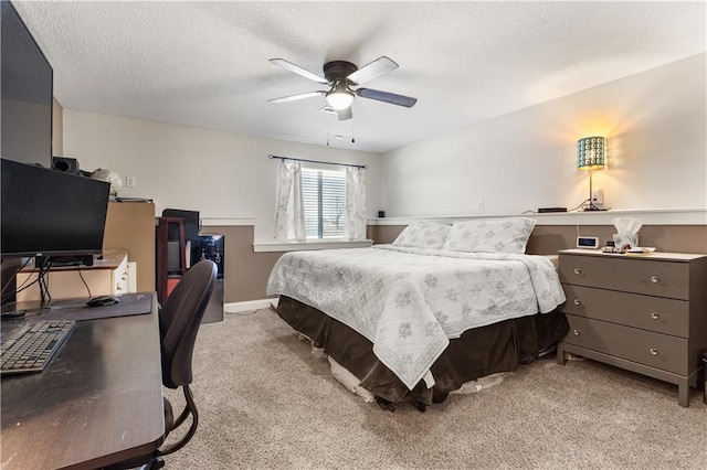 carpeted bedroom featuring ceiling fan and a textured ceiling