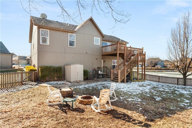 rear view of property with a deck and an outdoor fire pit