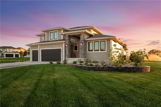 prairie-style house featuring a lawn and a garage