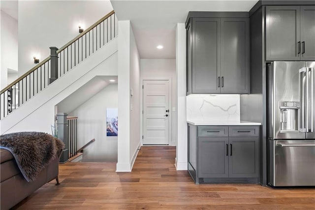 kitchen with high end fridge, gray cabinetry, backsplash, and dark hardwood / wood-style flooring