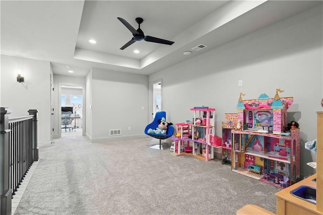 rec room featuring a raised ceiling, ceiling fan, and carpet flooring