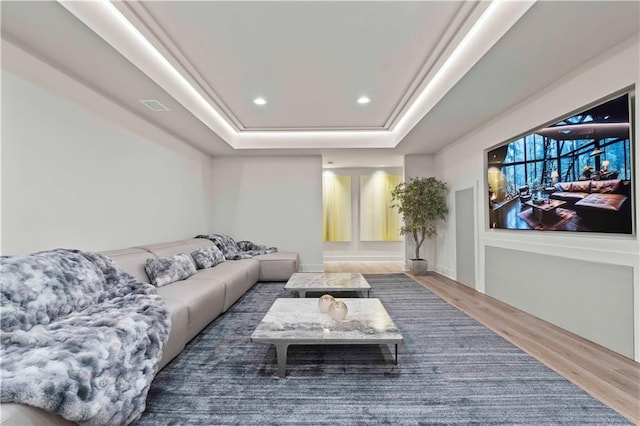 home theater featuring dark wood-type flooring and a raised ceiling