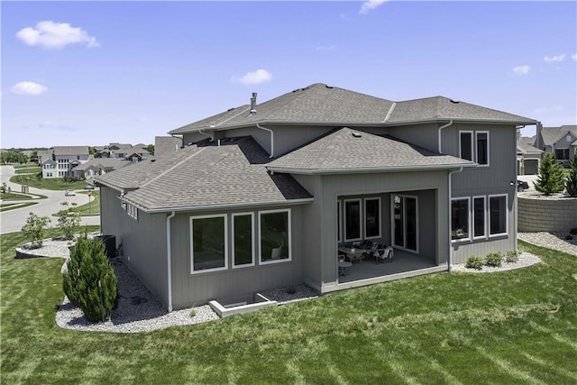 rear view of property featuring a yard and a patio area