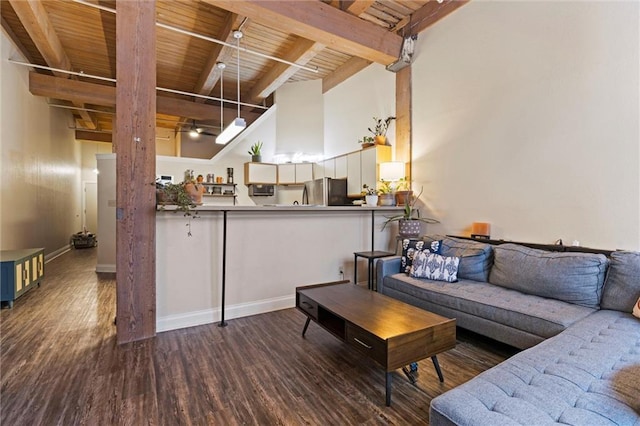 living room with baseboards, beamed ceiling, wood ceiling, a high ceiling, and wood finished floors