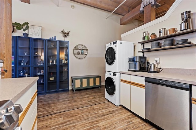 kitchen featuring stacked washer / dryer, light countertops, light wood-style flooring, appliances with stainless steel finishes, and open shelves