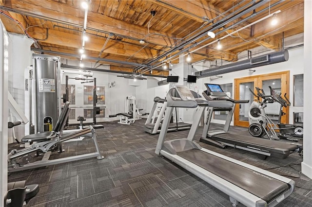 exercise room featuring carpet flooring, wood ceiling, and visible vents