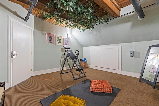 exercise area with baseboards, lofted ceiling, and carpet