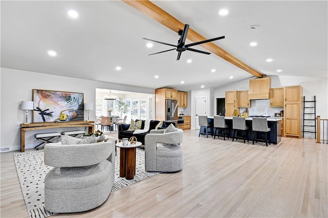 living room featuring vaulted ceiling with beams, ceiling fan with notable chandelier, and light wood-type flooring