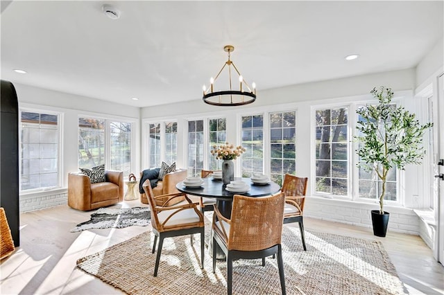 sunroom / solarium featuring a chandelier