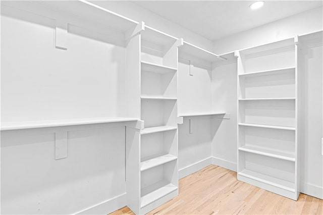 walk in closet with hardwood / wood-style floors