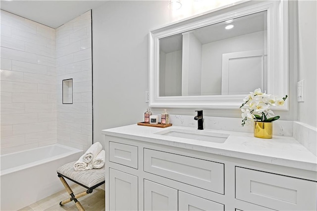 bathroom with tiled shower / bath and vanity