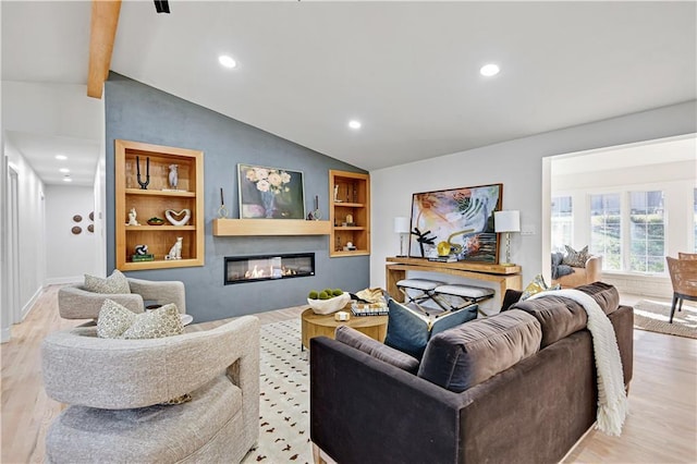 living room with lofted ceiling with beams, light hardwood / wood-style floors, and built in features