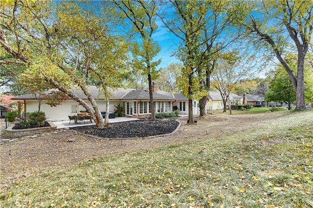 view of front of home featuring a front lawn and a patio area