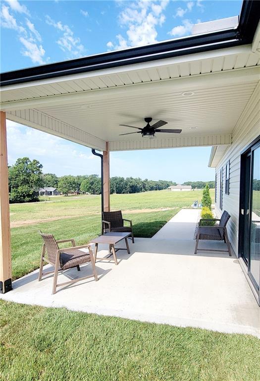 view of patio / terrace featuring ceiling fan and a rural view