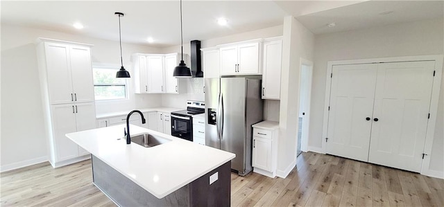 kitchen featuring stainless steel refrigerator with ice dispenser, sink, wall chimney range hood, white range with electric cooktop, and an island with sink