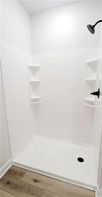 bathroom with wood-type flooring and walk in shower