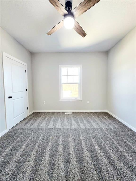 carpeted empty room featuring ceiling fan