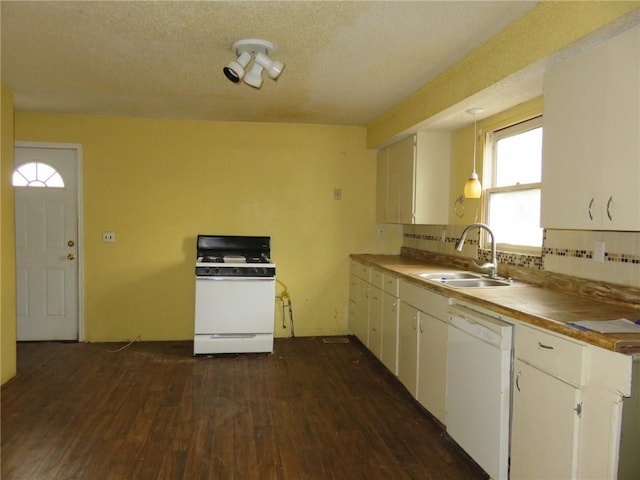 kitchen with pendant lighting, white appliances, white cabinets, sink, and decorative backsplash