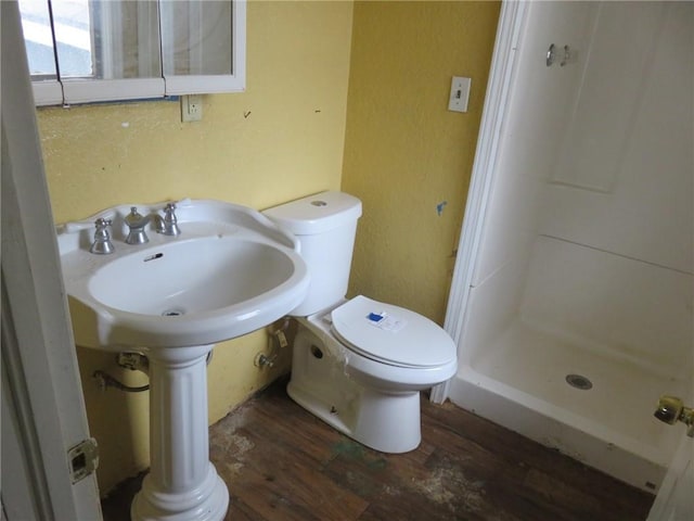 bathroom with a shower, hardwood / wood-style floors, and toilet