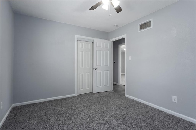 unfurnished room featuring ceiling fan and dark carpet