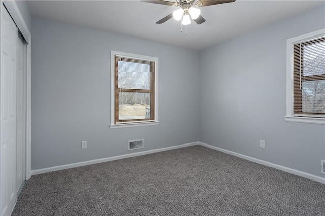 carpeted spare room featuring ceiling fan