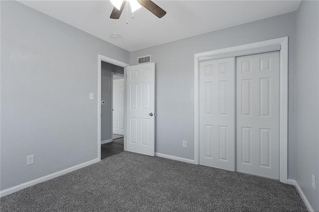 unfurnished bedroom with dark colored carpet, ceiling fan, and a closet