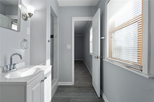 bathroom with vanity, ornamental molding, and hardwood / wood-style floors