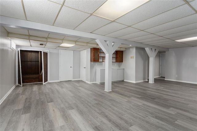 basement with a paneled ceiling and wood-type flooring