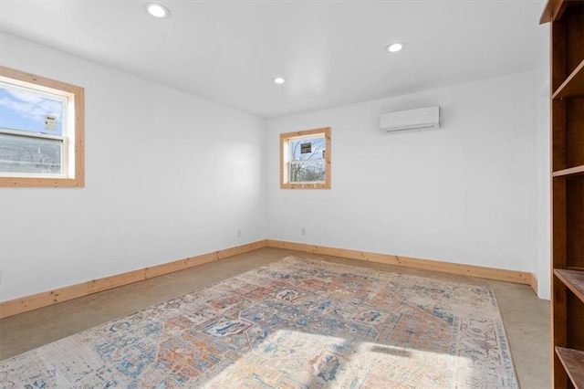 spare room featuring concrete flooring and a wall mounted AC