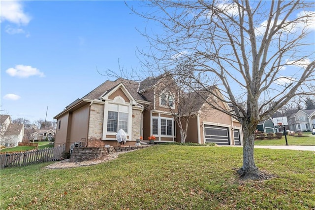 view of front of home with stone siding, fence, driveway, and a front lawn