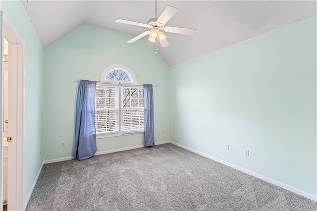 spare room featuring ceiling fan, baseboards, vaulted ceiling, and carpet flooring