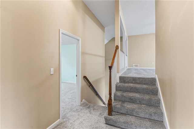 stairs with carpet flooring, visible vents, and baseboards