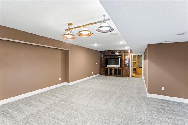 unfurnished living room with light carpet, visible vents, baseboards, and a textured ceiling