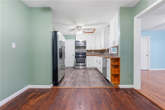 kitchen featuring white cabinets, ceiling fan, tasteful backsplash, dark hardwood / wood-style flooring, and stainless steel appliances