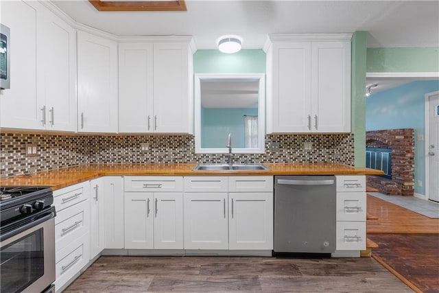 kitchen with white cabinets, sink, butcher block counters, and stainless steel appliances