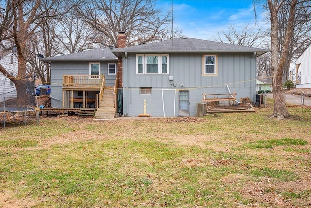 back of house featuring a lawn and a trampoline