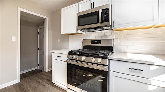 kitchen with white cabinets, decorative backsplash, stainless steel appliances, and dark hardwood / wood-style floors