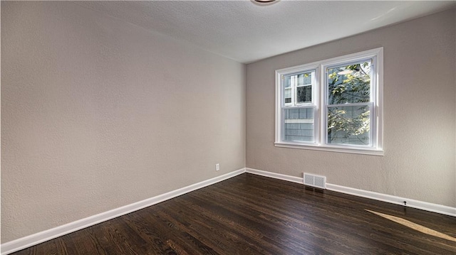 spare room featuring dark wood-type flooring