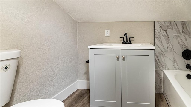 full bathroom with hardwood / wood-style floors, vanity, toilet, a textured ceiling, and shower / bathtub combination