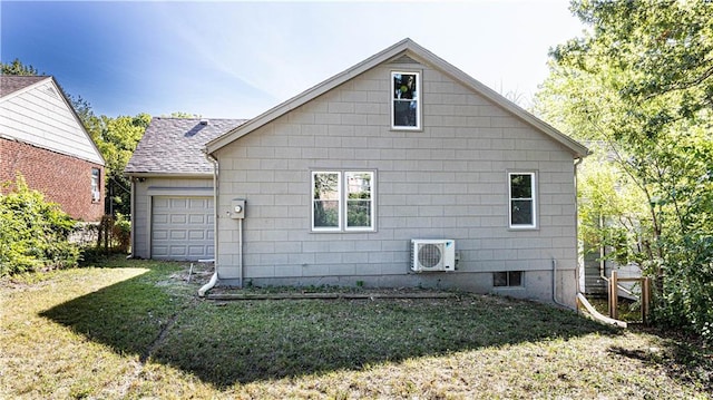 back of house with ac unit, a garage, and a lawn