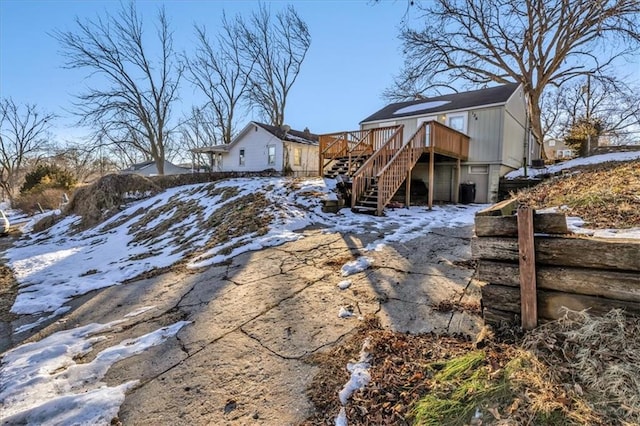 snow covered house featuring a deck