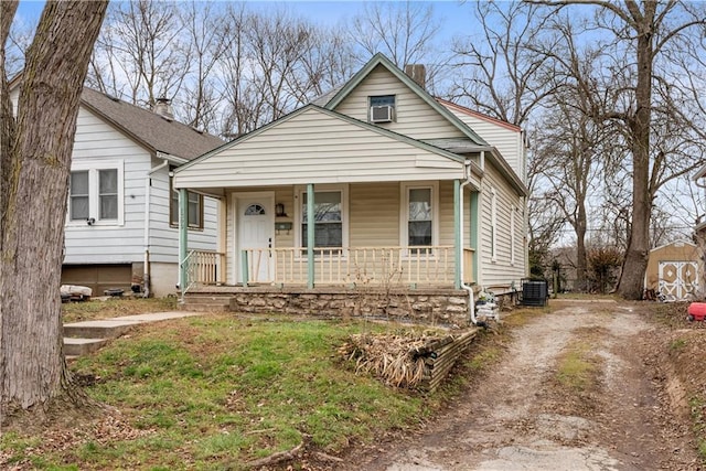 bungalow with central AC unit, a porch, and a shed