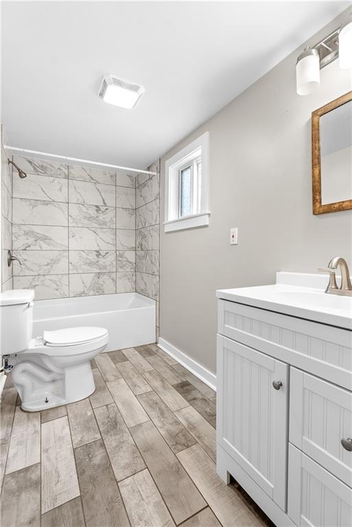 full bathroom featuring vanity, toilet, and tiled shower / bath combo