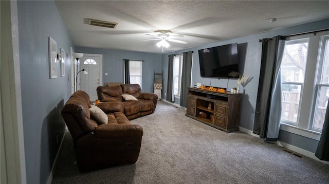 carpeted living room featuring a textured ceiling and ceiling fan