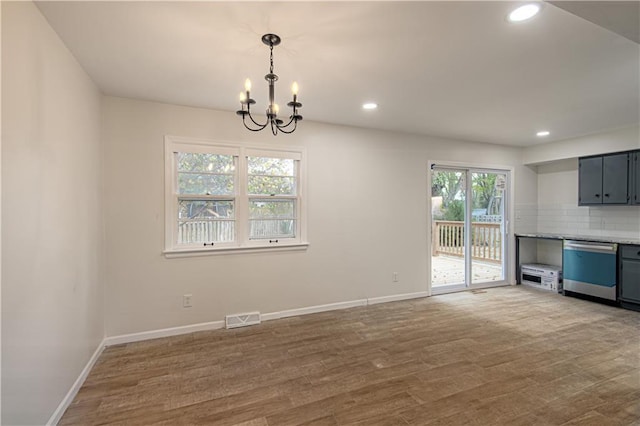 unfurnished living room with hardwood / wood-style floors and a chandelier