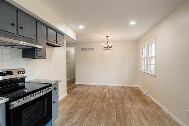 kitchen featuring an inviting chandelier, ventilation hood, hanging light fixtures, electric range, and light wood-type flooring