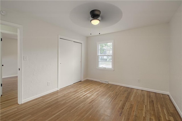 unfurnished bedroom featuring a closet, ceiling fan, and hardwood / wood-style flooring