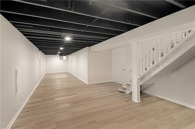 basement with light hardwood / wood-style flooring