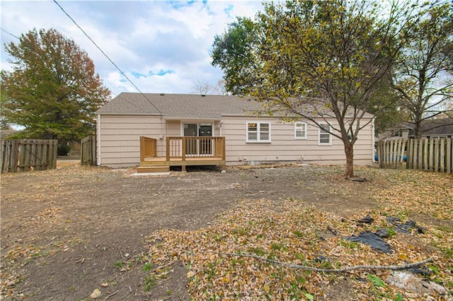 rear view of house featuring a wooden deck