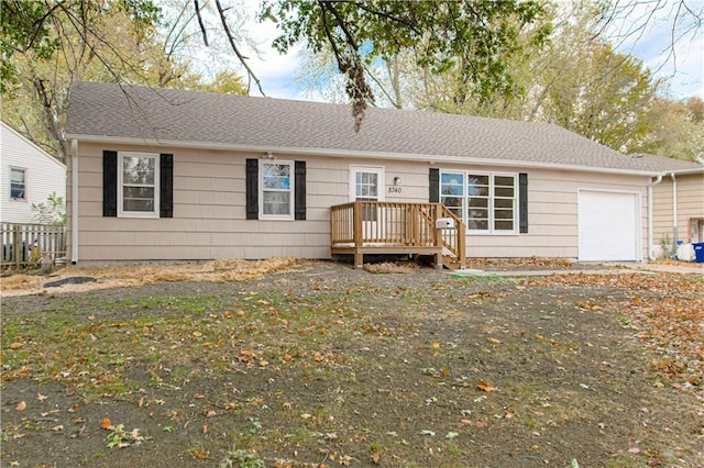 ranch-style home featuring a garage and a wooden deck